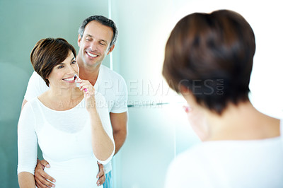 Buy stock photo Happy couple, mirror and brushing teeth with hug for dental care, grooming and morning in home. Mature man, woman and smile in reflection with toothbrush, oral health and wellness or house bathroom