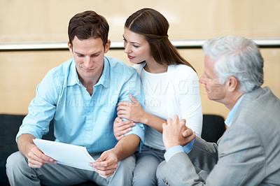 Buy stock photo Meeting, documents and lawyer with couple in office for prenup agreement, reading and advice. Marriage contract, legal advisor with man and woman in law firm for deal, estate planning and proposal