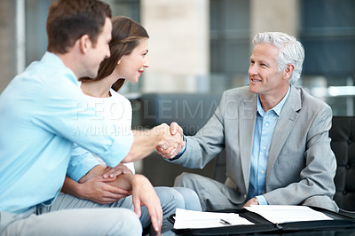 Buy stock photo Handshake, happy and couple with financial advisor in meeting, discussion and planning for future. Office, paperwork and consultant shaking hands for wealth management, finance advice and thank you
