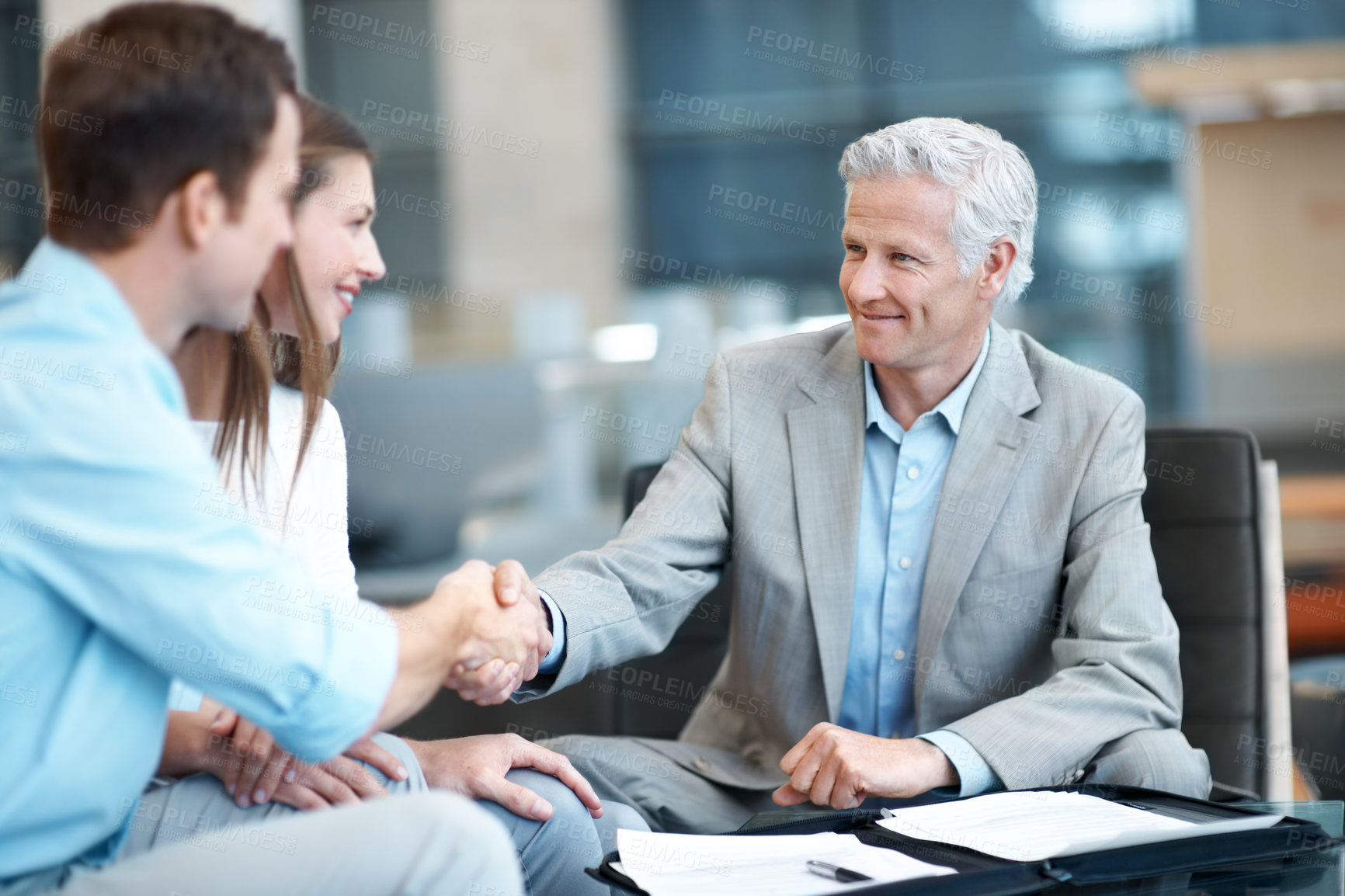 Buy stock photo Handshake, office and couple with financial advisor in meeting, discussion and planning for future. Happy, paperwork and consultant shaking hands for debt counseling, finance advice and thank you