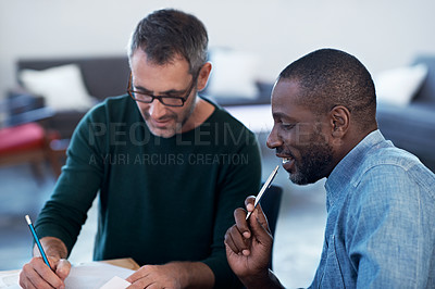 Buy stock photo Shot of two male coworkers talking together at a desk in an office
