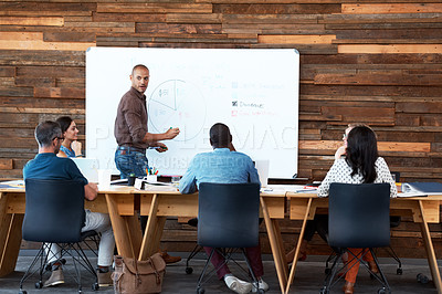 Buy stock photo Shot of a male office worker giving a financial presentation to his colleagues