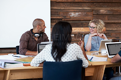 Buy stock photo Shot of a group of colleagues working on laptops around a table
