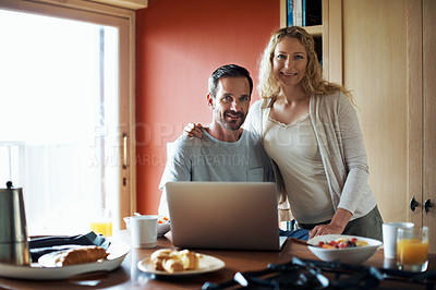 Buy stock photo Cropped shot of a couple using a laptop in the middle of breakfast