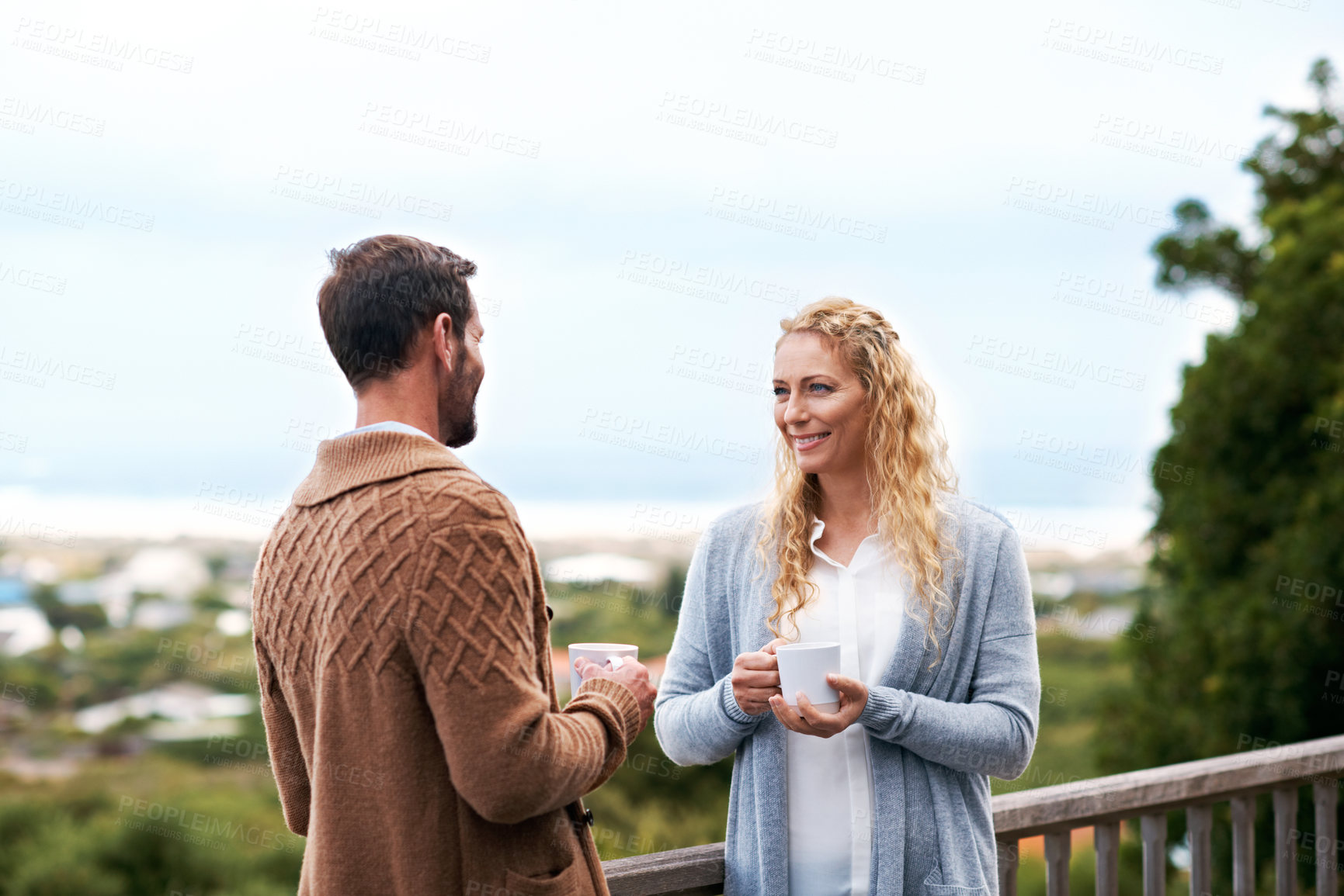 Buy stock photo Happy, talking and couple with coffee on balcony for bonding on vacation, break and relax outdoor. Marriage, morning and man with woman for connection, relationship and conversation at holiday house