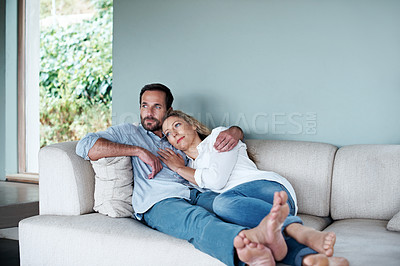 Buy stock photo Shot of a couple relaxing on their living room sofa