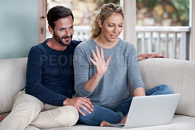 Buy stock photo Cropped shot of a couple chatting online while sitting on the sofa