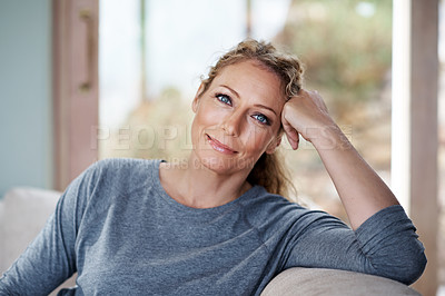 Buy stock photo Cropped portrait of an attractive woman relaxing on her living room sofa