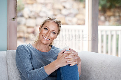 Buy stock photo Cropped portrait of an attractive woman relaxing on her living room sofa