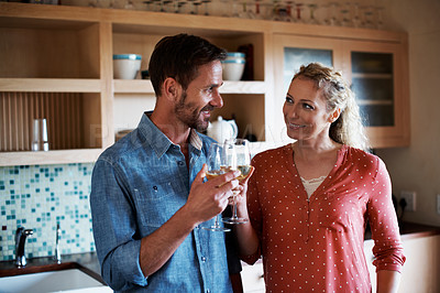Buy stock photo Cropped shot of an affectionate couple drinking wine in the kitchen