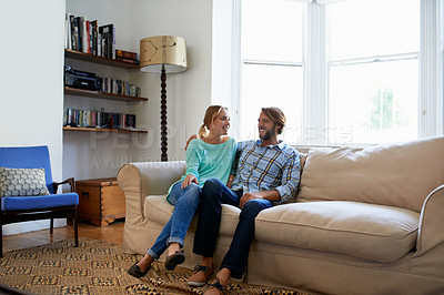 Buy stock photo Shot of a young couple relaxing on a sofa at home