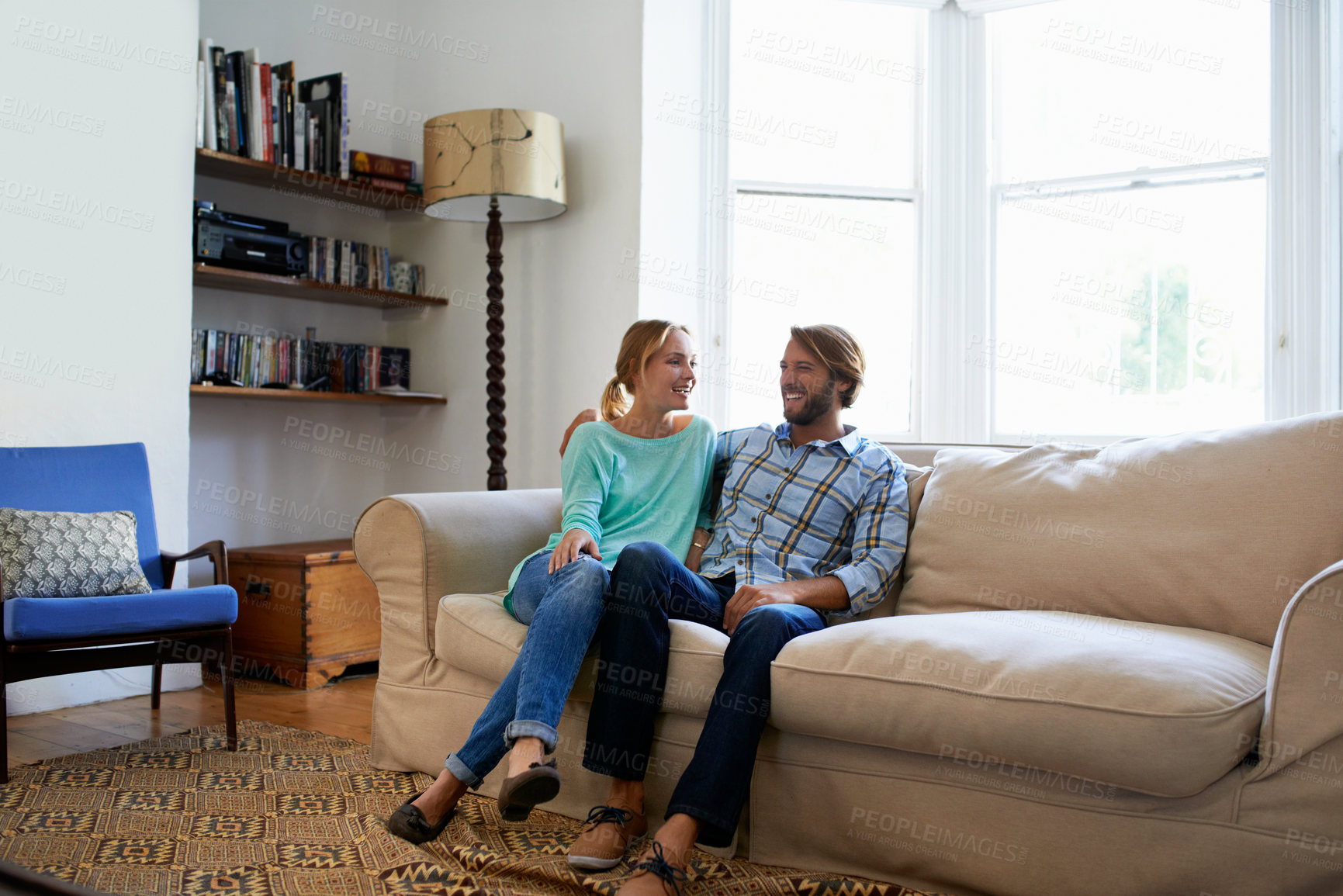 Buy stock photo Love, tender and couple on couch with hug, partner bonding and relax together on weekend break. Smile, embrace and people in house with day off, romantic moment and connection in happy relationship.