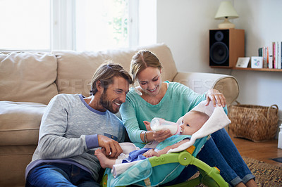 Buy stock photo Shot of a young couple feeding their baby at home