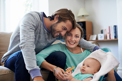 Buy stock photo Shot of a young couple playing with their baby at home