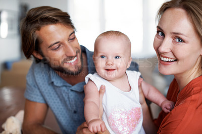 Buy stock photo Portrait of a young couple with their baby at home