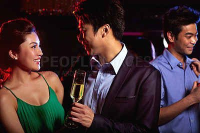 Buy stock photo Shot of a young couple enjoying a night out together in a club