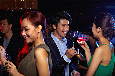 Buy stock photo Shot of a group of friends celebrating with drinks in a nightclub