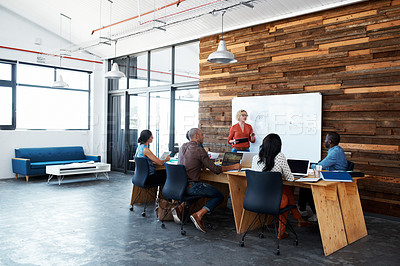 Buy stock photo Shot of a female office worker giving a financial presentation to her colleagues