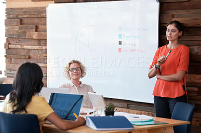Buy stock photo Shot of a female office worker giving a financial presentation to her colleagues