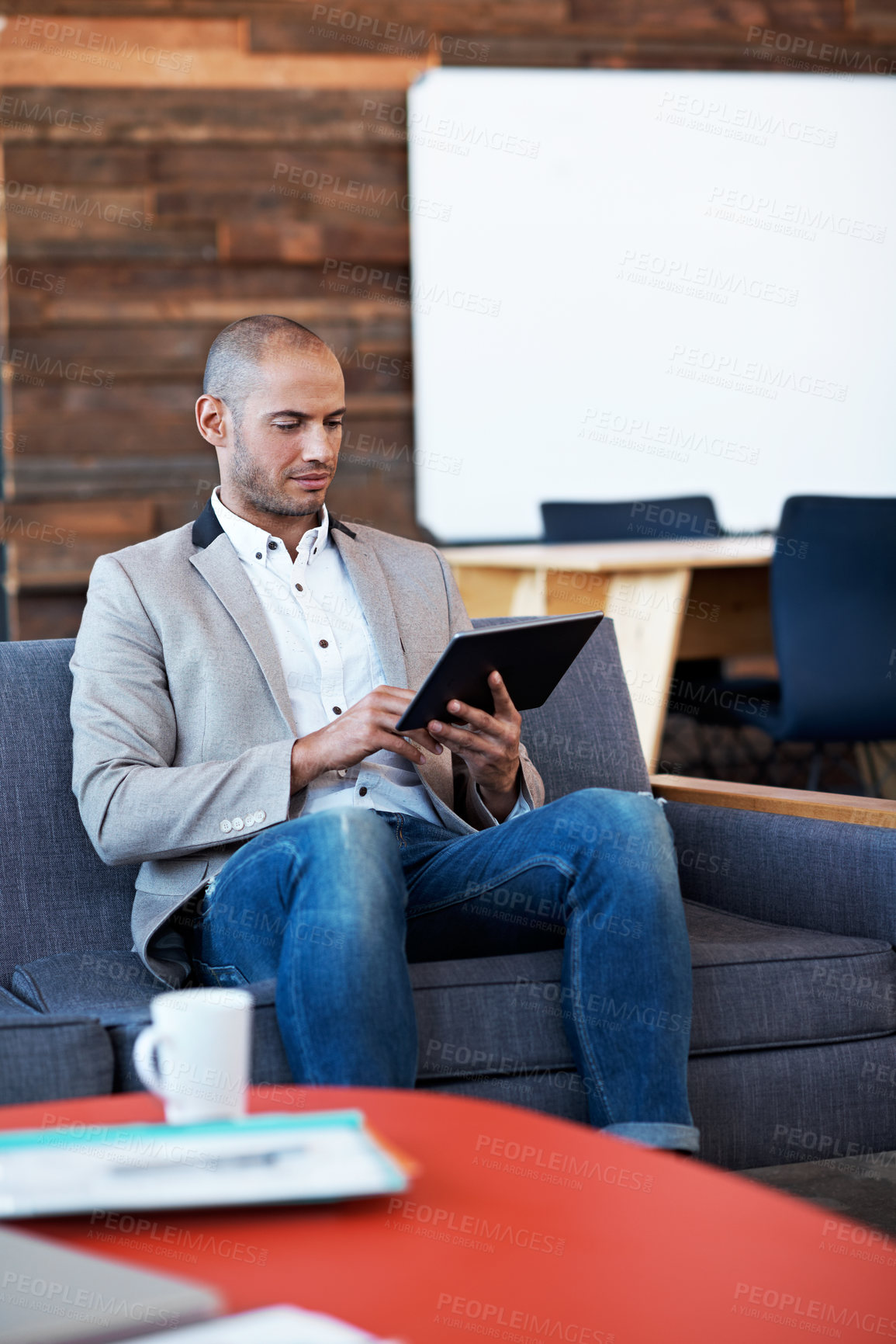 Buy stock photo Shot of a handsome man using his laptop in a modern office