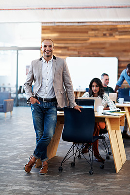 Buy stock photo Portrait of a handsome designer with his colleagues blurred in the background