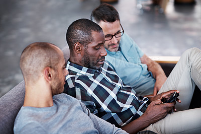 Buy stock photo Shot of a group of male colleagues having a conversation in an modern office