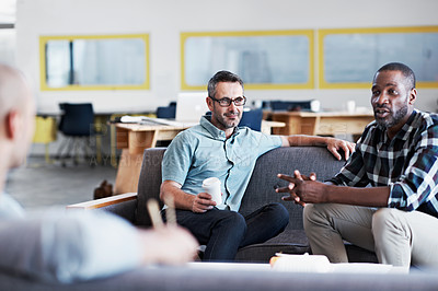 Buy stock photo Shot of a group of male colleagues having a conversation in an modern office