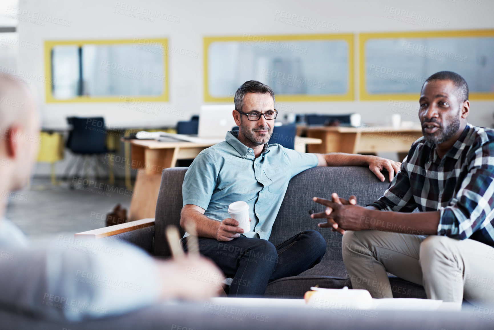 Buy stock photo Talking, planning and business men on sofa in office for advice, feedback or tips on startup. Happy, discussion and team of creative editors in conversation for review on project in workplace.