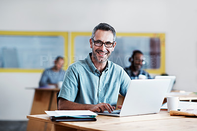 Buy stock photo Portrait of a man using his laptop with his colleagues blurred in the background