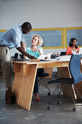 Buy stock photo Shot of a man assisting his coworker with their colleague blurred in the background