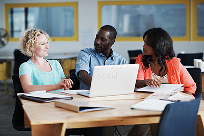 Buy stock photo Shot of three colleagues working together on a laptop