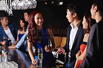 Buy stock photo Shot of a group of friends drinking together in a bar