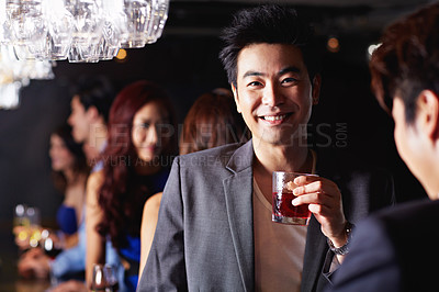 Buy stock photo Portrait of a handsome young asian man enjoying a night out in a bar