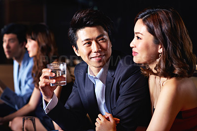 Buy stock photo Shot of a young couple enjoying a night out together in a bar