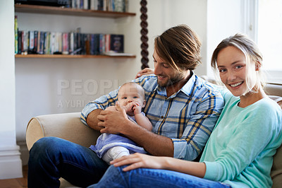 Buy stock photo Shot of a young couple playing with their baby at home