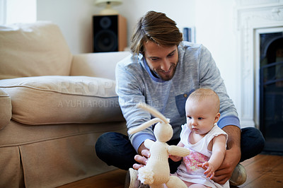 Buy stock photo Shot of a smiling father playing with his baby girl at home