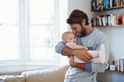 Buy stock photo Shot of a smiling father playing with his baby girl at home