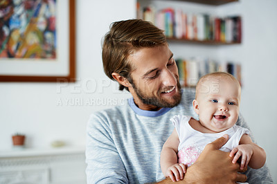 Buy stock photo Shot of a smiling father playing with his baby girl at home