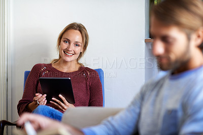 Buy stock photo Shot of a young couple relaxing with a book and digital tablet in the living room