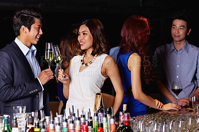 Buy stock photo Shot of a young couple enjoying a night out together in a bar