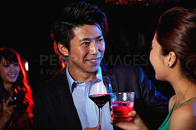 Buy stock photo Shot of a young couple enjoying a night out together in a bar