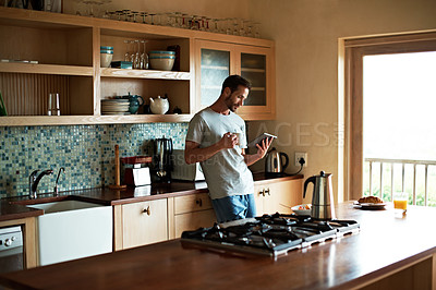 Buy stock photo Cropped shot of a handsome man eating breakfast while using a tablet