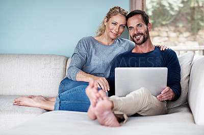 Buy stock photo Cropped shot of a couple using a laptop while relaxing on the sofa