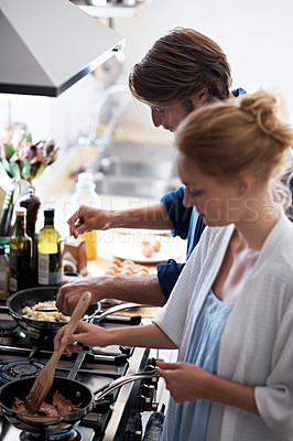 Buy stock photo Shot of a young couple making breakfast together in the kitchen