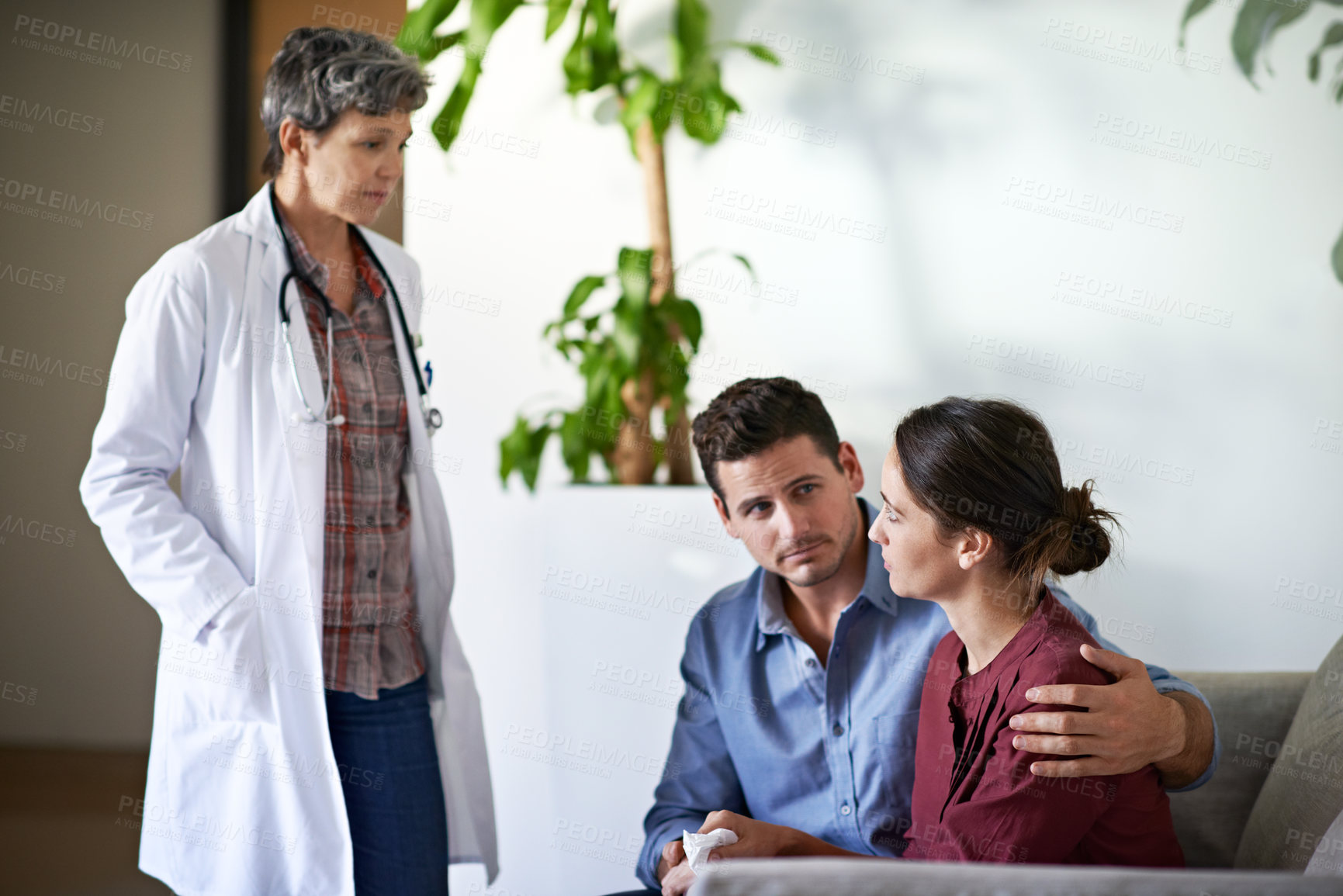Buy stock photo Comfort, couple and doctor in hospital waiting room for healthcare discussion, feedback or review. Grief, hug and medical professional speaking to sad people in lobby of clinic for bad news report