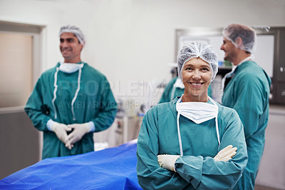 Buy stock photo Portrait of a confident doctor in the operating room with her surgical team in the background