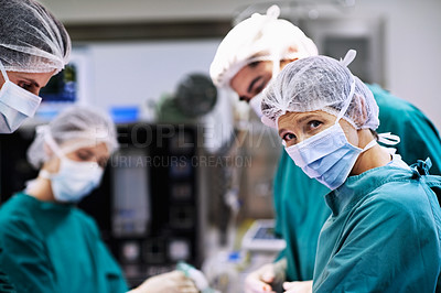 Buy stock photo Shot of a team of surgeons performing an operation