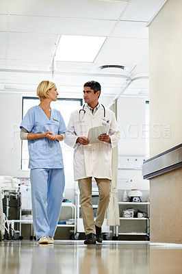 Buy stock photo Shot of two doctors having a discussion in a hospital corridor