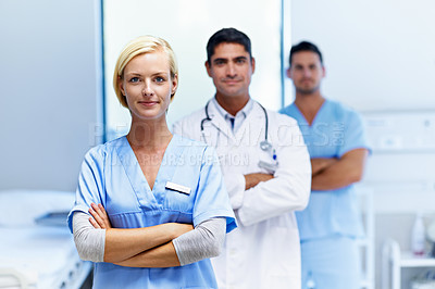 Buy stock photo Portrait of a confident doctor with medical staff in the background