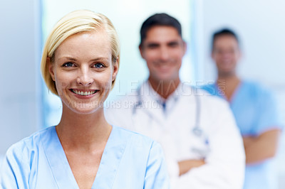 Buy stock photo Portrait of a confident doctor with medical staff in the background